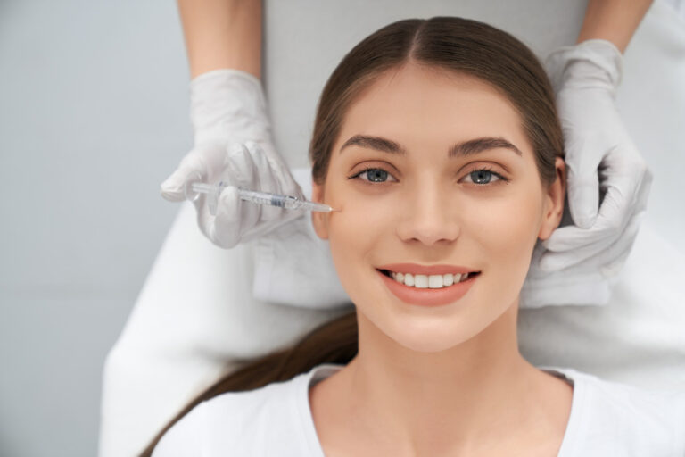 Professional administering Botox or dermal filler facial injections, helping clients choose the right aesthetic treatment option in Beverly.