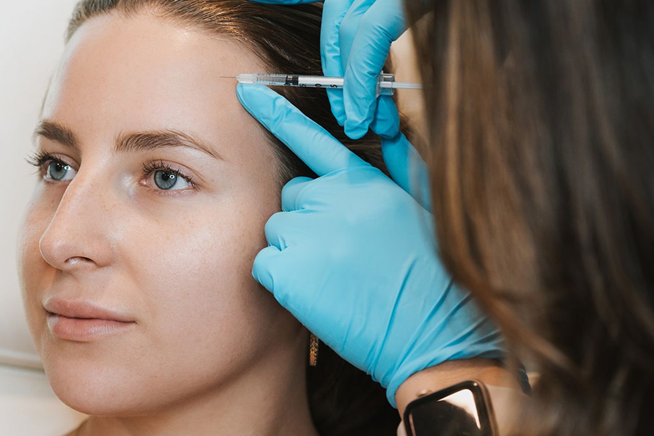 Aesthetic practitioner administering Botox injections to a patient’s forehead, illustrating the procedure discussed in the ultimate guide to Botox treatments.