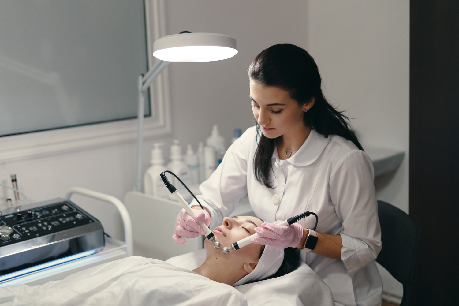 Licensed aesthetician performing a professional facial treatment in a clean clinic setting, helping clients choose the right aesthetician in Beverly.