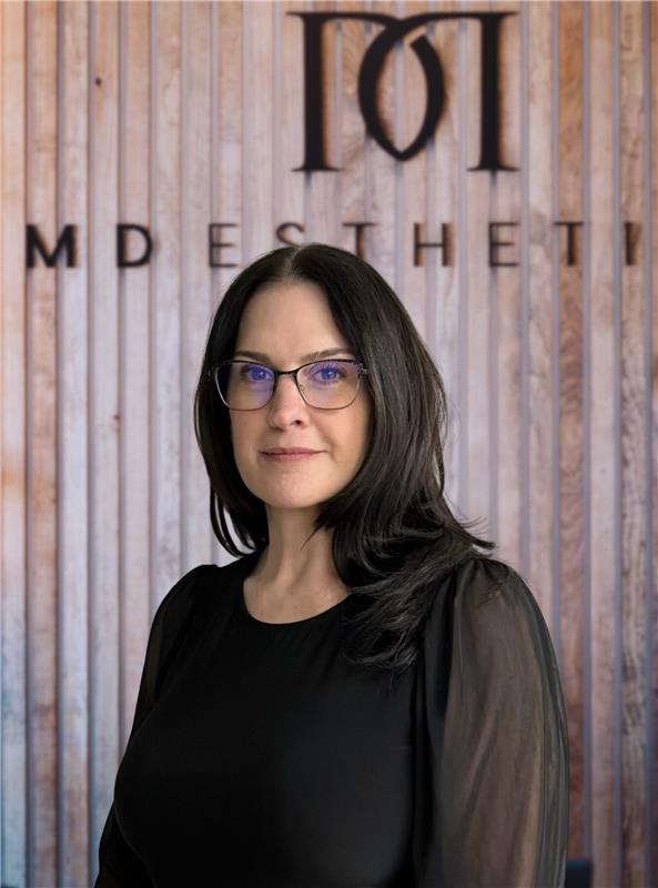 Donna, team member at MD Esthetics, professional headshot in front of the MD Esthetics logo.